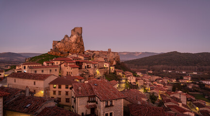 Obraz premium Panoramic landscape of the medieval village of Frías with old stone buildings and castle in the tophill at sunset, Burgos, Castile and Leon, Spain