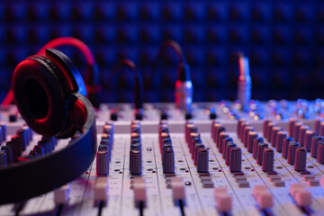 Headphones on sound mixer with faders and music cable jack. Audio equipment in record studio