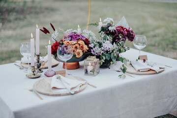 Modern wedding table decorated with plates, cutlery and flowers