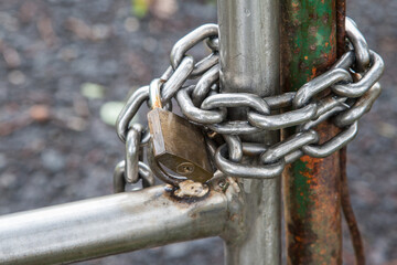 Under lock. Steel chain with padlock on a steel gate.