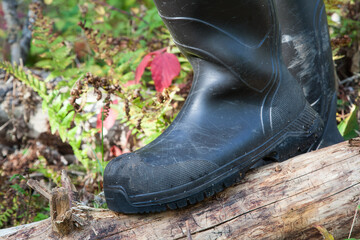 Rubber boots for your outdoor adventure. Man stands in the wilderness with his hiking rubber boots...