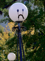 A lamp on a bridge with a smiley face daubed on it.