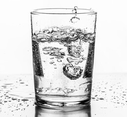 Water being poured into a glass. White background..