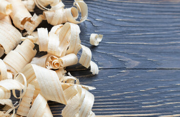 Wood shavings on a wooden background with a place for text. Repair, needlework.