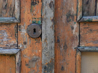 close-up on the door, old and wooden, structural elements, slats and the keyhole plate for the lock