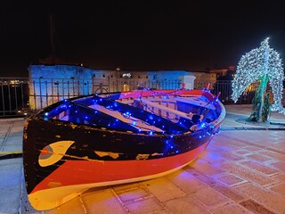 Fototapeta na wymiar Natale a Taranto, barchetta davanti al castello aragonese