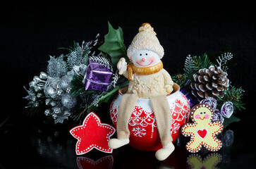 Toy snowman and Christmas decorations on a black background