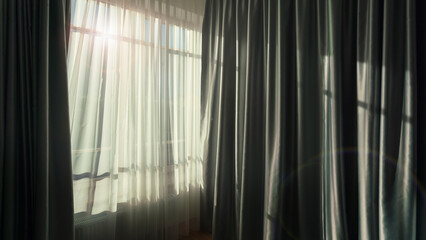 Sunlight illuminate empty room through transparent curtain hanging in cozy bedroom at home or hotel room