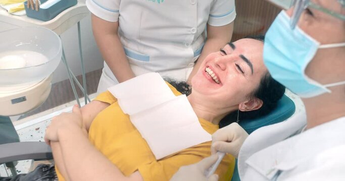 Woman dentist with a patient in dental office are happy about result installation of braces and teeth alignment. Dentistry very happy. Close-up female teeth with brackets. Health and medicine concept