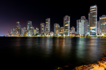 Fototapeta na wymiar Buildings reflected in the sea at night in Castillogrande. Cartagena, Bolivar, Colombia. 