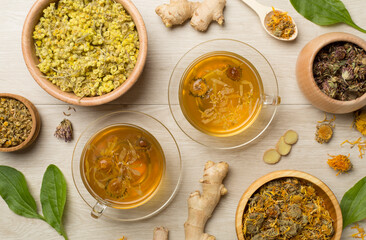 Herbal tea with ingredients on wooden background, top view