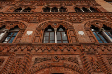 Beautiful colored vintage art red brick building facade. European architecture. Journey to Italy