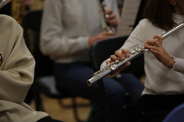 Fototapeta premium A student playing the flute in the school orchestra at a rehearsal in the classroom