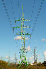 Power transmission line pylons with threatening blue clouds background