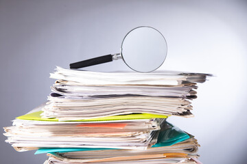 Pile of papers and a magnifying glass on the table