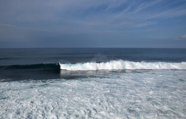 The waves crashing in the ocean, with a bluish tint at Drini Beach, Gunungkidul, Yogyakarta