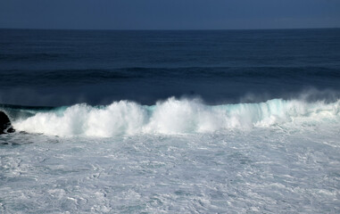 The waves crashing in the ocean, with a bluish tint at Drini Beach, Gunungkidul, Yogyakarta
