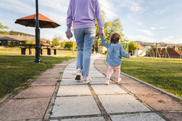 Obraz premium back view of unknown mother and child caucasian woman and toddler