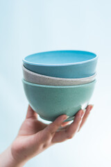 Hand holding some blue ceramics pots on bright blue background	