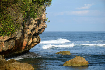 The waves crashing in the ocean, with a bluish tint at Drini Beach, Gunungkidul, Yogyakarta, Indonesia