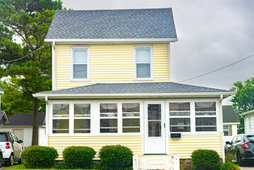 small two-story American house with a well-groomed lawn in a seaside village.