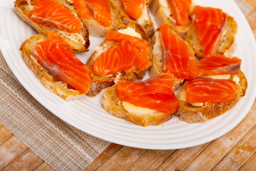 Naklejka na ściany i meble Closeup of tasty sandwiches with bread and fresh sliced salmon fillet