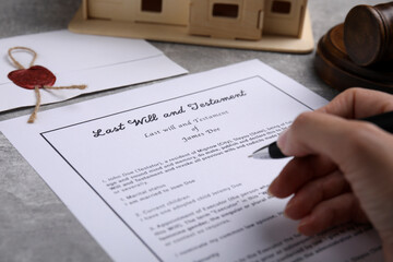 Woman signing last will and testament at light grey table, closeup - obrazy, fototapety, plakaty