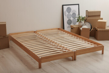 Wooden bed frame and cardboard boxes on floor in room