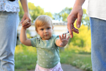 Woman smoking cigarette in public place outdoors, closeup. Don't smoke near kids