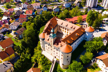 Aerial view of impressive medieval Gewerkenegg Castle in small Slovenian township of Idrija on sunny autumn day - obrazy, fototapety, plakaty