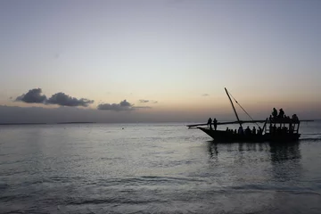 Tableaux ronds sur aluminium Plage de Nungwi, Tanzanie Kendwa, Zanzibar Island, Tanzania dhow boat sailing against the setting sun and cloudy sky.