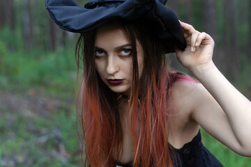 a girl in a witch costume with a pentagram around her neck is standing in the forest.costume idea...