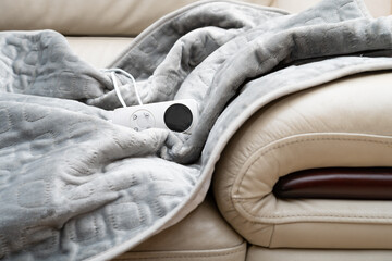 electric blanket with controller on a sofa