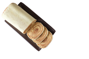 Sliced bolo de rolo (roll cake) on a brown plate. Brazilian traditional sweet (PNG).