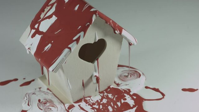 Red and White Paint Pours Onto Wooden Birdhouse 4K