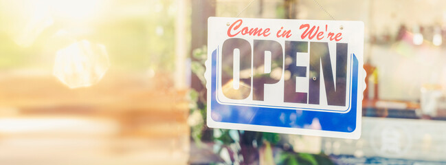 We're open board sign on entrance door to business Hotel, cafe, local shop, service owner welcoming...
