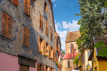 Obraz premium One of the many picturesque and colorful streets and alleys of half-timbered buildings in the medieval village of Ribeauville, France, in the Alsace wine region of Northeast France.