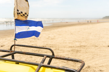 Nicaraguan flag waving on an ATV motorcycle parked on the beach of Masachapa in Managua, Nicaragua