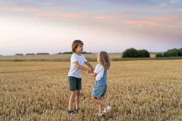 Happy and free people, children run through the beveled field of wheat