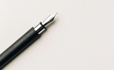 Close up of fountain pen on  empty bullet journal page.