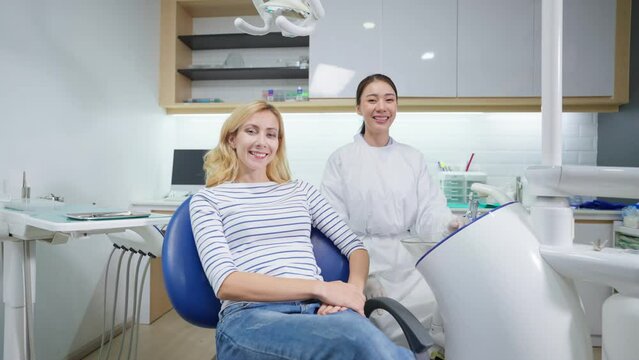 Portrait of Caucasian woman patient and dentist at health care clinic.