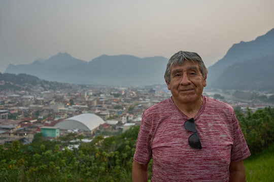 Senior person standing in front of a mountain in the Peruvian Jungle 
