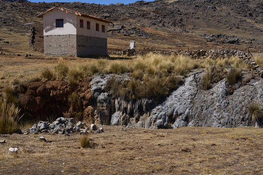 Casa rural ubicada sobre terreno rocoso y agreste en valle de vegetaci&oacute;n andino 
