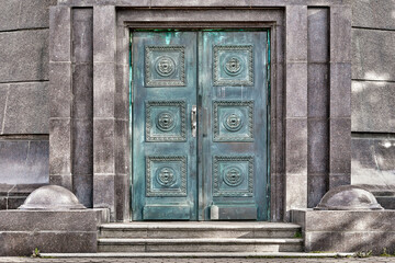 Fototapeta na wymiar Double metal door with stone staircase, close-up. Vintage green door to the house.