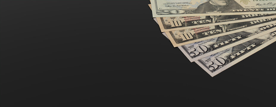 Mixed Denomination Bills on a Black surface. Banking concept Banner with copy-space.