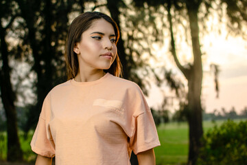 A young woman looking to the side with the sun behind