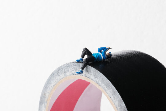 miniature of a man playing cellphone while lying down, wasting time concept