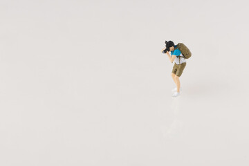miniature of a photographer holding a bag in a shooting position, travel photographer concept