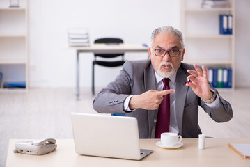 Old businessman feeling bad at workplace