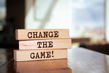 Wooden blocks with words 'CHANGE THE GAME'.